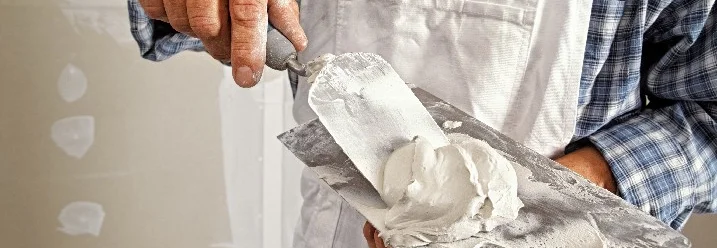 Person hält Spachtel mit Spachtelmasse
